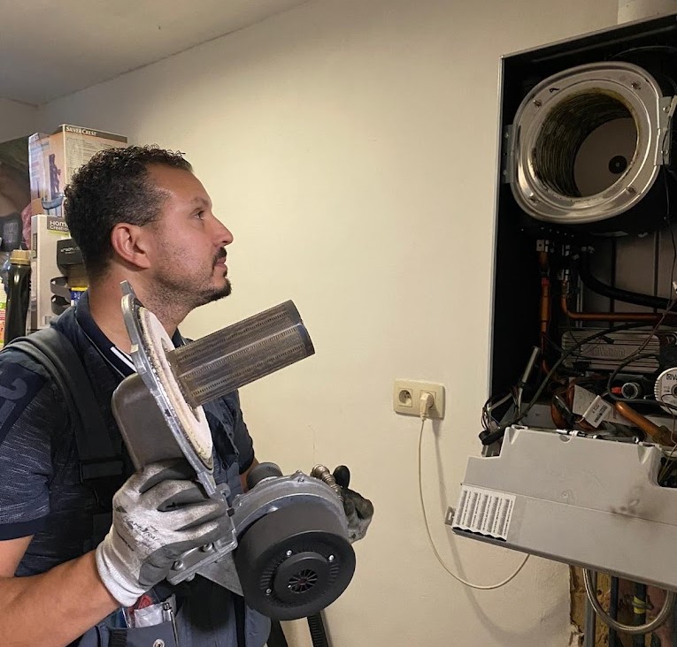Monteur van Aquatec & CV met een onderdeel van een ketel in zijn handen