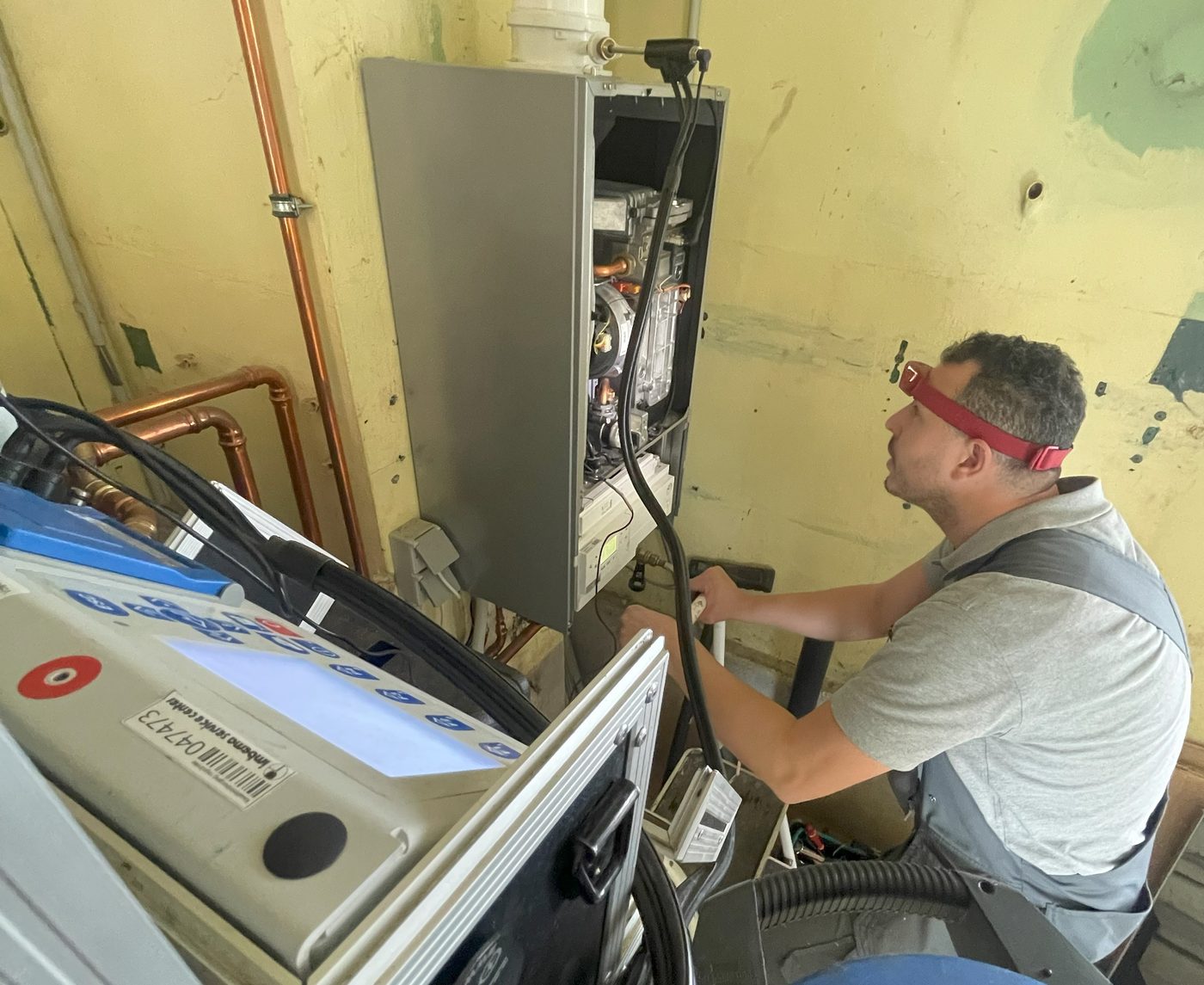 Monteur van Aquatec & CV onderhoudt een cv-ketel met een meettoestel